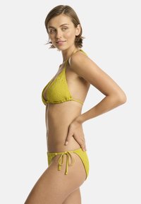 Geel bikini set met een getextureerd patroon, met een triangle bovenstuk en verstelbare strik-onderkant, gemaakt van een flexibel materiaal.