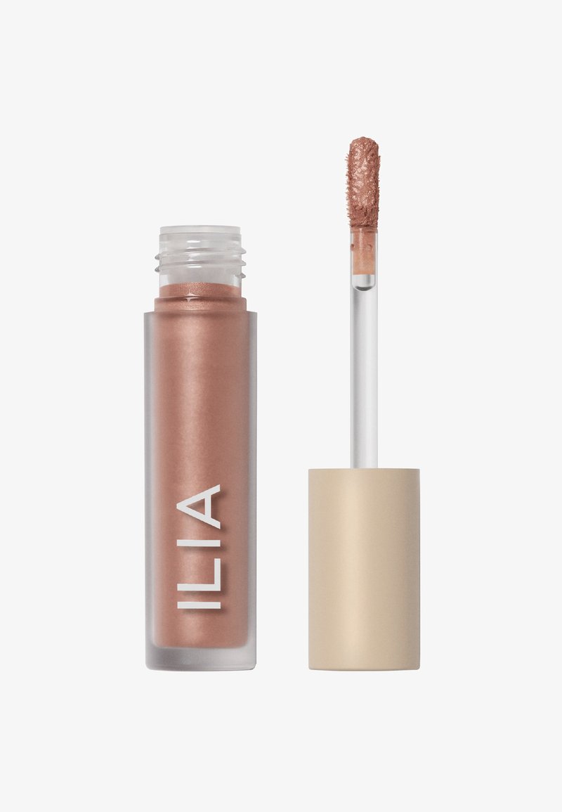 Glanzende lipproduct in een doorzichtige tube met een roségouden tint. Voorzien van een doe-foot applicator en een matte beige dop. Het "ILIA" logo is duidelijk zichtbaar.