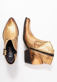 Gold, textured ankle boots with a pointed toe, features a zipper on the side, and a small stacked heel. Scaly pattern on synthetic material.