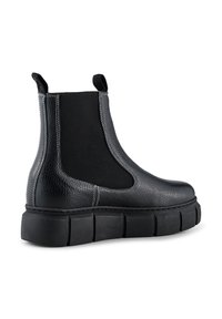 Botines Chelsea de cuero negro con paneles laterales elásticos, parte superior texturizada y suela de goma gruesa. Los detalles de costura añaden estructura y contraste.