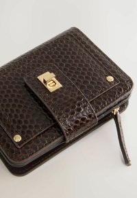 Brown, patent leather wallet with a textured hexagonal pattern. Features a gold clasp closure and zipper, with a side loop for easy carrying.