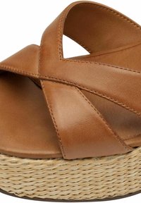 Sandale compensée en cuir marron avec un design à brides croisées. La base en jute tissé naturel ajoute texture et hauteur. Fini lisse et mat sur le dessus.