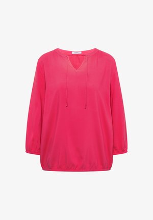 Lyserød bluse med lange ærmer, elastiske manchetter, V-udskæring med snore, og løs pasform.