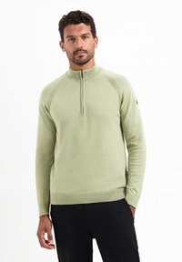 Lichtgroene gebreide pullover met een hoge kraag, een halve rits en ribgebreide boorden. Gladde textuur en aansluitend ontwerp voor comfort.