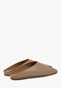 Beige leather slip-on mules with a pointed toe and open back. Textured outer sole with minimalistic design and smooth finish.