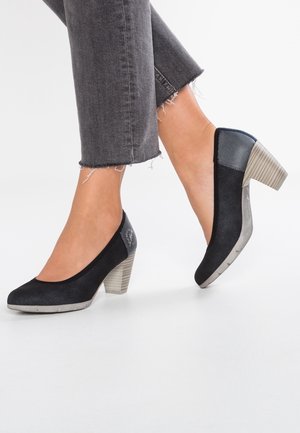 Escarpins noirs avec un bout arrondi, dessus en tissu texturé et un design de talon contrastant. Le talon présente des rainures ; les semelles sont légères et plates.