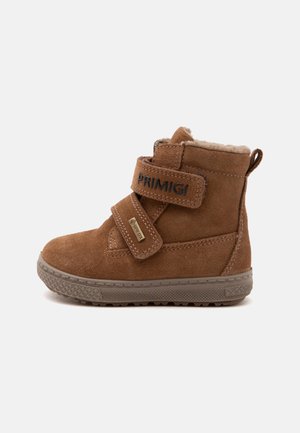 Brauner Veloursleder-Kinderknöchelstiefel mit zwei Klettverschlüssen, Futter aus Fleece und grauer Gummisohle, gekennzeichnet mit Primigi- und Gore-Tex-Etiketten.