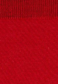 Nahaufnahme eines roten Strickstoffs mit einer gerippten Textur oben und einer glatten Strickstruktur darunter.