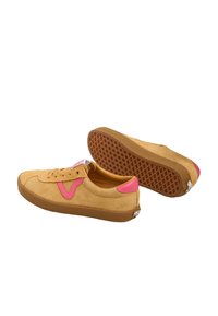 Ein Paar beige Wildledersneaker mit pinken Akzenten und braunen Gummisohlen, wobei ein Schuh das strukturierte Sohlenmuster zeigt.