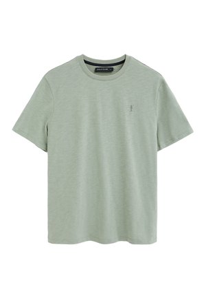 Hellgrünes kurzärmeliges T-Shirt mit Rundhalsausschnitt, kleinem gesticktem Polo-Spieler-Logo auf der linken Brust und "Polo Club"-Etikett im inneren Kragen.