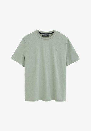 T-shirt verde chiaro a maniche corte con scollo rotondo, con un piccolo logo ricamato di un giocatore di polo sul petto a sinistra e l'etichetta "Polo Club" all'interno del colletto.