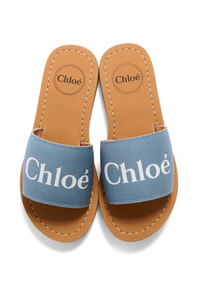 Jasnobrązowe skórzane sandały wsuwane z szerokimi, jasnoniebieskimi paskami z materiału, każdy pasek ozdobiony białym logo "Chloé".