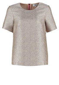 Krátký rukáv kovově texturovaná blůza s kulatým výstřihem a viditelným růžovým zipem na zadní straně, béžové a stříbrné tóny.