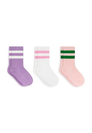 Trois paires de chaussettes côtelées mi-mollet : violettes avec des rayures blanches, blanches avec des rayures roses et roses avec des rayures vertes, posées à plat sur un fond blanc.