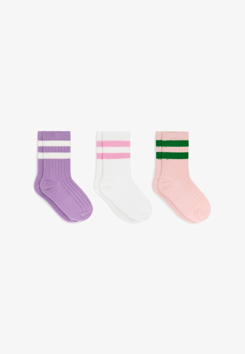 Trois paires de chaussettes côtelées mi-mollet : violettes avec des rayures blanches, blanches avec des rayures roses et roses avec des rayures vertes, posées à plat sur un fond blanc.
