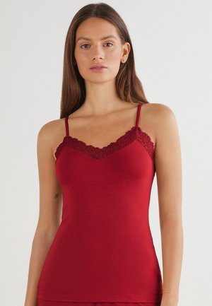 Débardeur rouge en matériau doux, avec un délicat bord en dentelle le long du décolleté et des bretelles spaghetti réglables. Texture lisse et coupe ajustée.