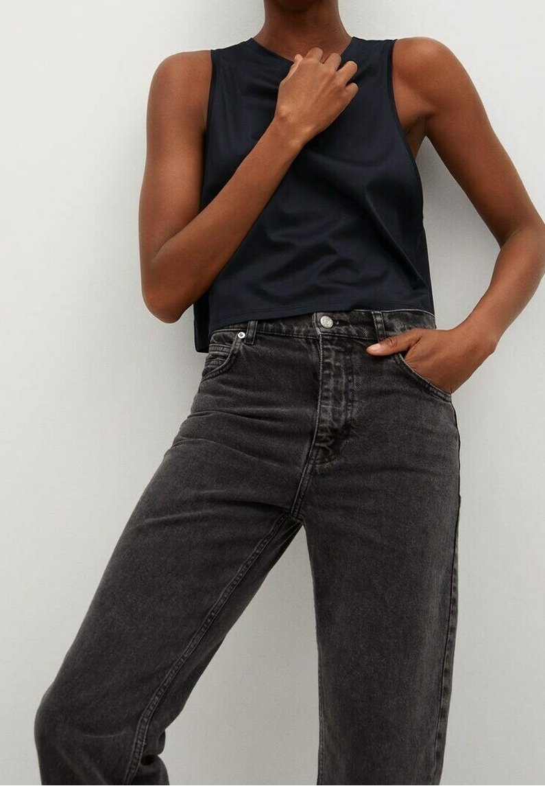 Top corto nero realizzato in un tessuto liscio e opaco, abbinato a jeans in denim grigio scuro a vita alta con un classico design a cinque tasche.