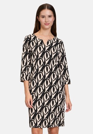 Robe noire et beige à motifs avec des manches trois-quarts, décolleté en V et coupe décontractée, arborant un design géométrique en forme d'œil sur l'ensemble.