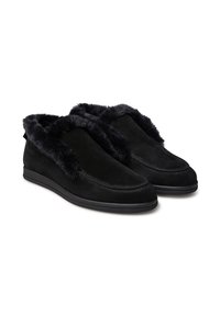 Pantofole in suede nero con un morbido rivestimento interno in pelliccia sintetica nera. Caratterizzate da un design slip-on e una suola piatta in gomma. Nessun hardware visibile.