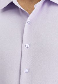 Camicia button-up viola chiaro in tessuto testurizzato, con colletto aperto e tre bottoni sul davanti.