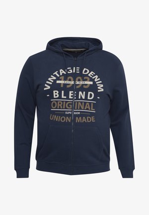 Navy blue zip-up hoodie made of soft fabric, featuring a front pocket and large graphic text in cream and gold, stating "Vintage Denim 1993 Blend."