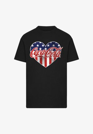 Schwarzes T-Shirt mit einem Herzdesign in Rot, Weiß und Blau, verziert mit Sternen und Streifen, sowie dem Coca-Cola-Logo in einer stilisierten Schrift.