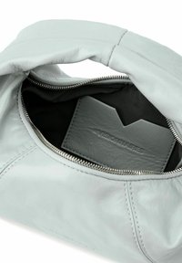 Interno di una borsa in pelle grigio chiaro con fodera nera, dotata di chiusura con zip e un portacarte grigio testurizzato. Cuciture a vista.
