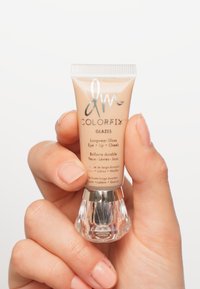 ColorFix Glazes lip- en cheekglans in een beige tube, heldere basis, met zilveren tekst en een geribbelde dop. Soepele textuur en glanzende afwerking.