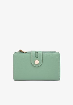 Portafoglio in pelle verde menta con finitura testurizzata, chiusura con zip e un accento in metallo dorato a forma di cerchio sulla parte anteriore.