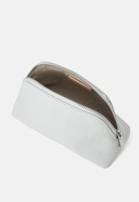 White textured leather pencil case with a silver zipper, triangular shape, and a spacious interior lined in beige fabric.