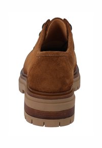 Scarpa in suede marrone con retro arrotondato, caratterizzata da una suola in gomma spessa con un accento in legno a contrasto e un motivo di battistrada texturizzato.