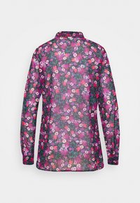 Chemise à manches longues avec un motif floral dans des tons de rose, violet et blanc, fabriquée en matière transparente avec un col et un ourlet arrondi.
