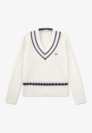 Vit stickad tröja med djup V-ringning, med texturerade mönster, ribbade ärmar och kontrasterande ränder i marinblått och rosa. Liten logotypdetalj.