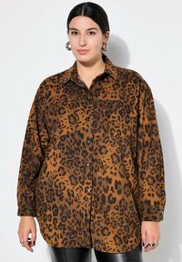 Brun leopardprint skjorte med krave, lange ærmer og frontknapper. Struktureret stof med en løs pasform og to brystlommer.