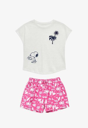 Chemise blanche à manches courtes avec motif de palmier bleu marine et Snoopy, associée à un short rose à taille élastique avec des motifs tropicaux blancs et Snoopy.