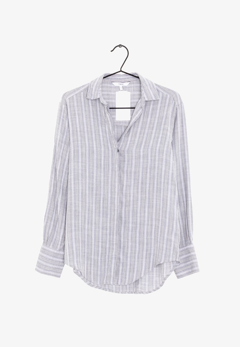 Chemise à rayures verticales gris clair et blanc à manches longues, accrochée sur un cintre noir avec une étiquette blanche.