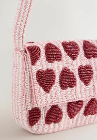 Gyöngyözött kézitáska rózsaszín alapon, texturált felület, piros szívmintákkal. A fedélzár és a pánt azonos anyagból készült.