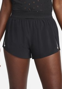 Mustat juoksushortsit hengittävällä rakenteella, jossa on verkkovyötärö ja sivuleikkaukset. Vasemmassa lahkeessa valkoinen Nike-logo.
