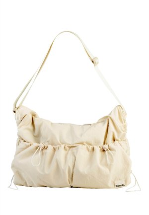 Beige verstelbare schoudertas met trekkoordvakjes en een klein "Bench." logo-label op de rechterbenedenhoek.