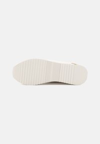 White rubber shoe sole with deep ridges. Smooth texture, rounded toe, and minimal design. Features slight heel for added support.