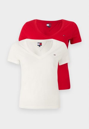 Two v-neck t-shirts: one red and one white. Both feature short sleeves and a small logo accent on the chest. Made from cotton blend material.