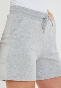 Pantaloni corti in cotone grigio misto con vita elastica e coulisse, dotati di due tasche laterali e una finitura morbida e texturizzata.