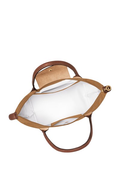 Leather tote bag with brown handles and cream interior. Features a flat base, snap closure, and no additional pockets.