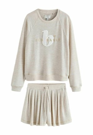 Beige langärmliges Sweatshirt aus Waffelstrick mit "b by Ted Baker"-Logo und passendem plissierten Rock mit Kordelzug.