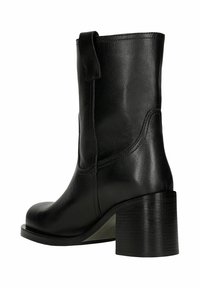 Botte en cuir noir mi-mollet avec talon bloc, bout arrondi, languette latérale et finition lisse, vue de côté.