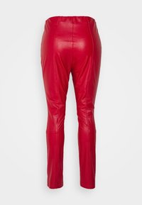 Rode neplederen broek met een slank, aansluitend ontwerp. Hoge taille met een gladde textuur en minimale stikdetails. Naad van het linkerbeen zichtbaar.