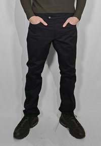 Pantaloni neri con design a gamba dritta, realizzati in un tessuto liscio. La vita ha una chiusura con bottone, con tasche ai lati.