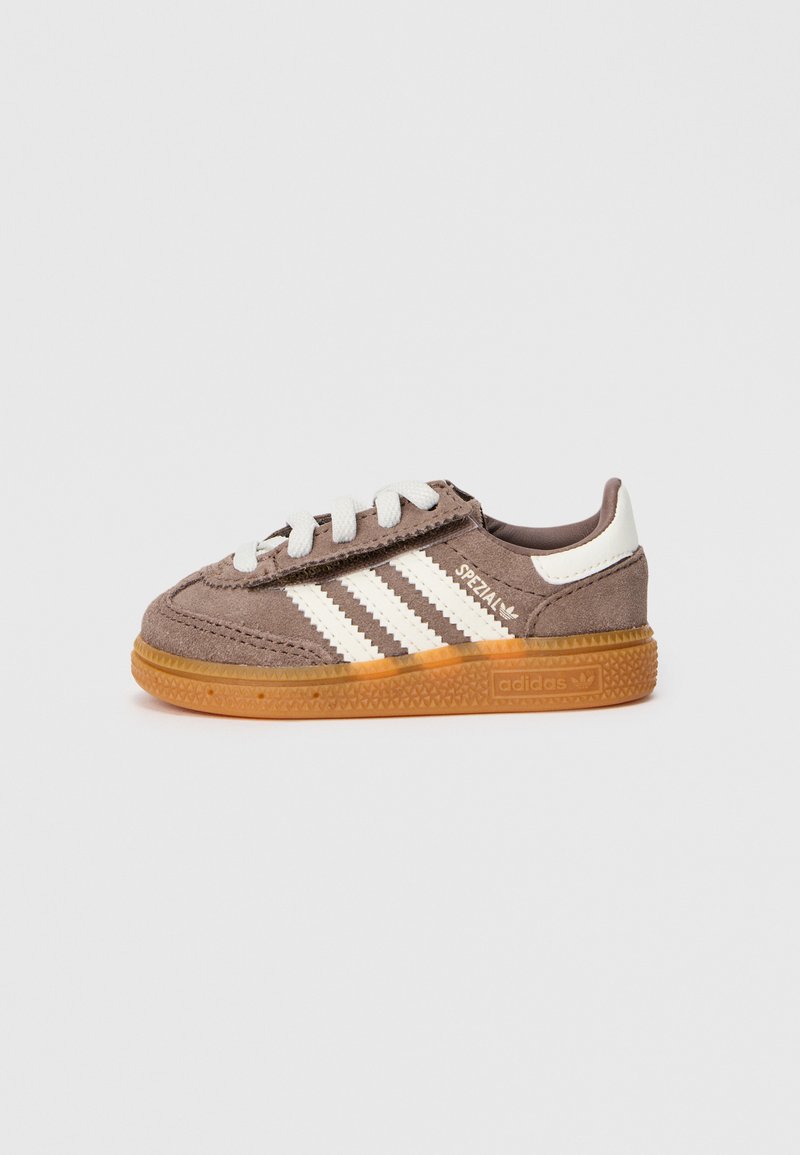 Sapatilhas Adidas Spezial de camurça castanha com riscas brancas, atacadores brancos e sola de borracha colorida, exibidas sobre um fundo branco simples.