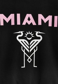 Tela negra con el gran texto rosa "MIAMI" en la parte superior. Debajo, un diseño gráfico blanco con aves estilizadas, sol y formas geométricas.