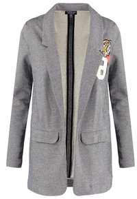 Šedý blazer s texturovanou látkou, dvěma předními kapsami a vyšitým detailem tygra na levé straně hrudi. Otevřený přední design.